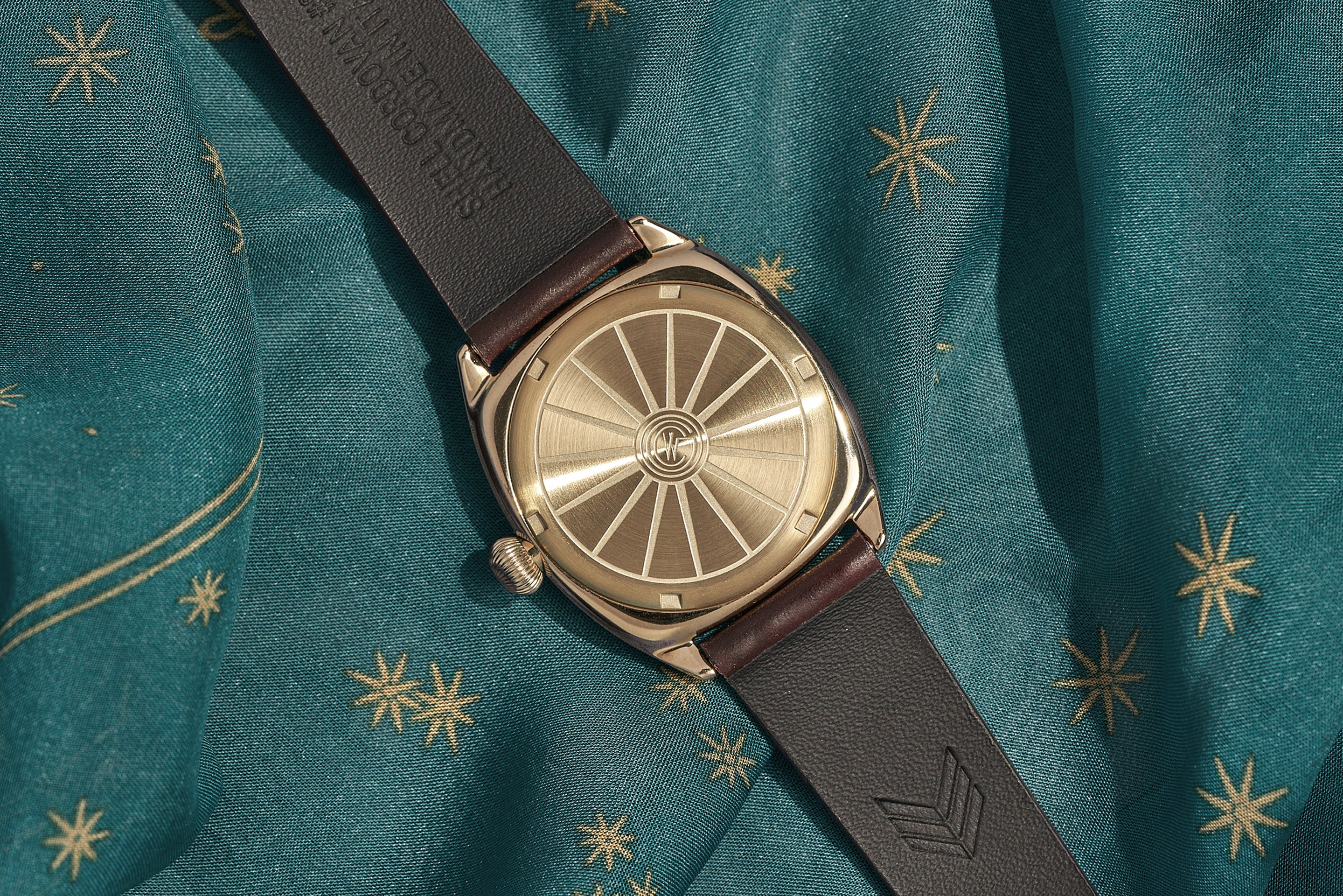 The Lorier watch face-down, exposing the engraved logo on the back of the watch.